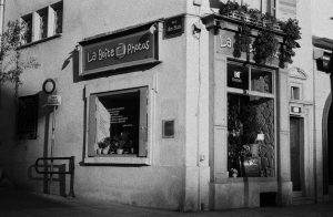 Vintage black and white photo of a charming urban photo shop corner.
