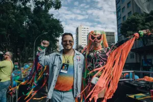 People in vibrant costumes celebrating at an outdoor pride event, exuding joy and inclusivity.