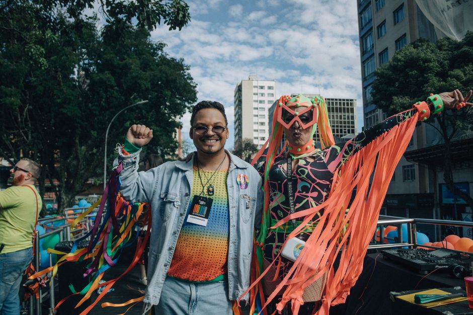 People in vibrant costumes celebrating at an outdoor pride event, exuding joy and inclusivity.